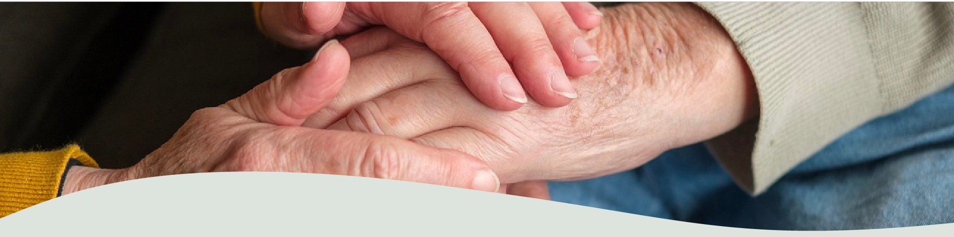 Close-up of gently clasped elderly hands, symbolizing love, trust, and lifelong connection at a caring senior community in East China, Michigan.